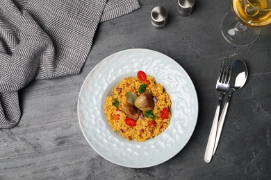 Plate with rice pilaf and meat on grey background, flat lay