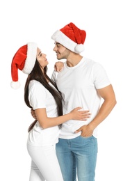 Photo of Young happy couple with Santa hats on white background. Christmas celebration