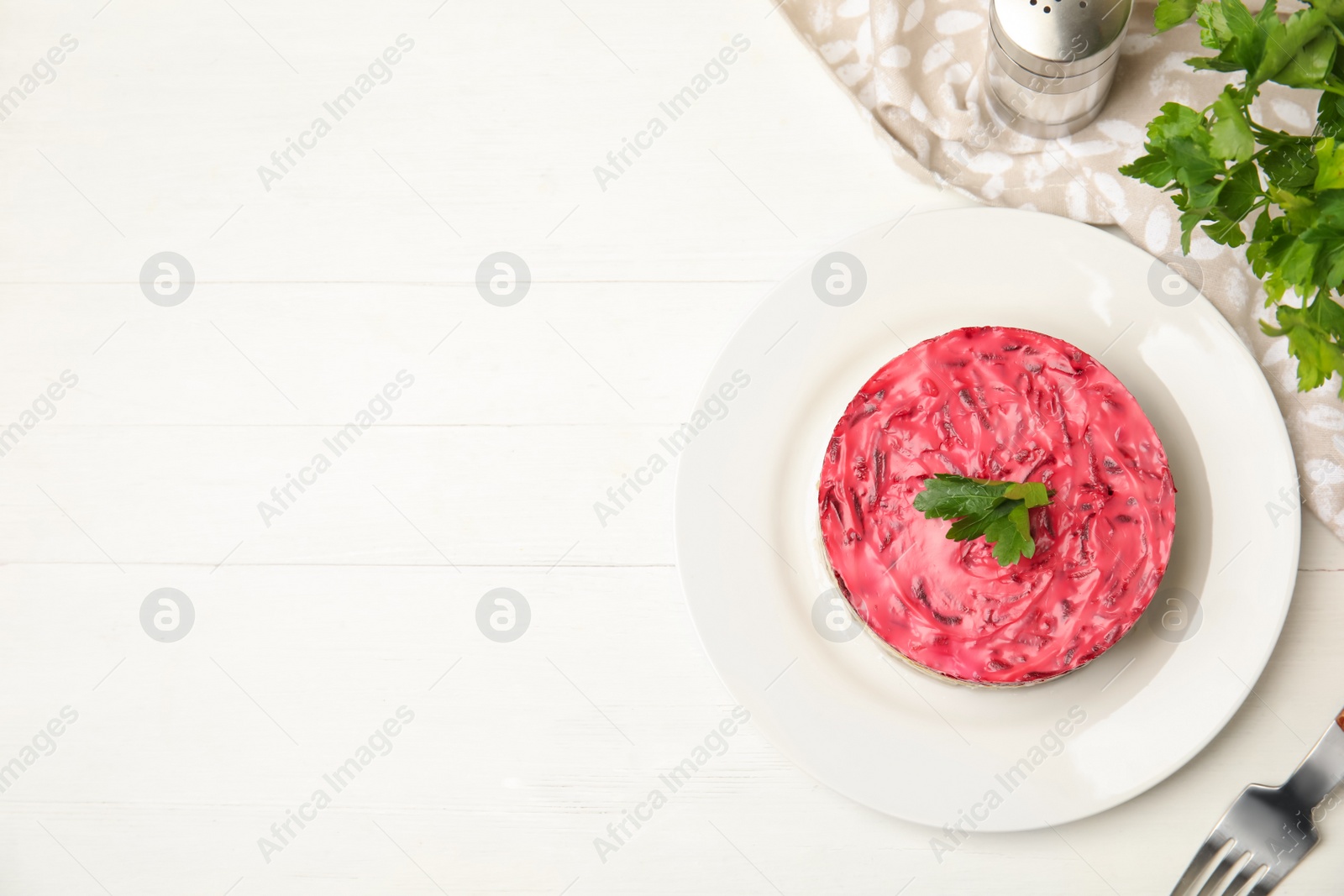 Photo of Herring under fur coat served on white wooden table, flat lay with space for text. Traditional russian salad