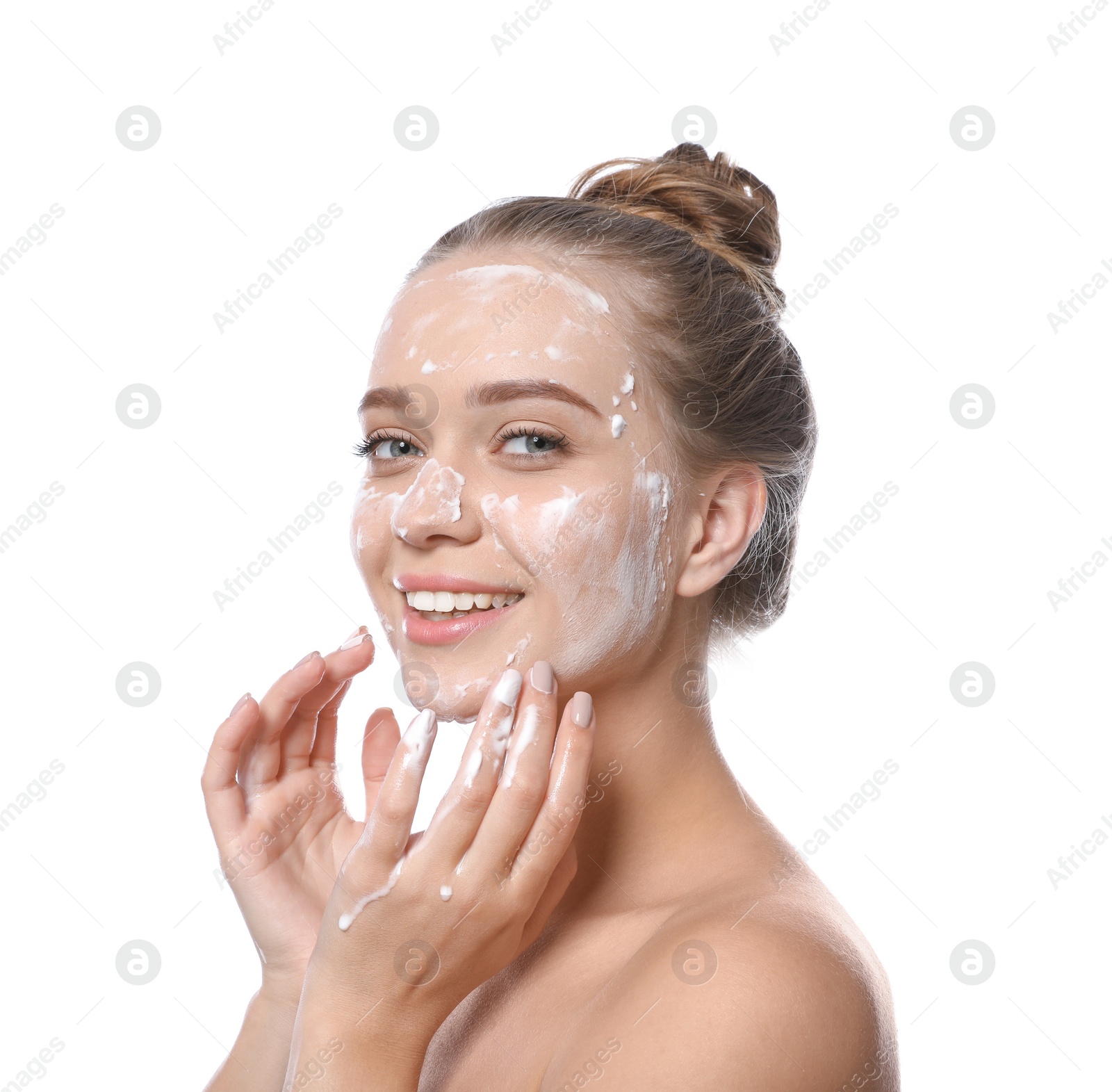 Photo of Young woman washing face with soap on white background