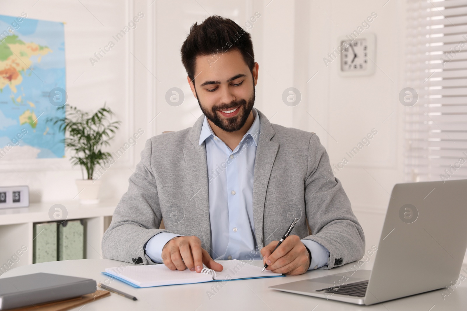 Photo of Happy manager working at desk in travel agency