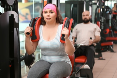 Overweight woman training in gym