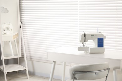 Photo of Sewing machine on white desk in workshop