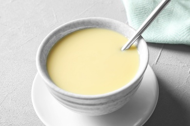 Photo of Bowl with condensed milk served on table. Dairy products