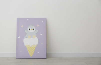 Photo of Adorable picturepenguin and ice cream on floor near white wall, space for text. Children's room interior element