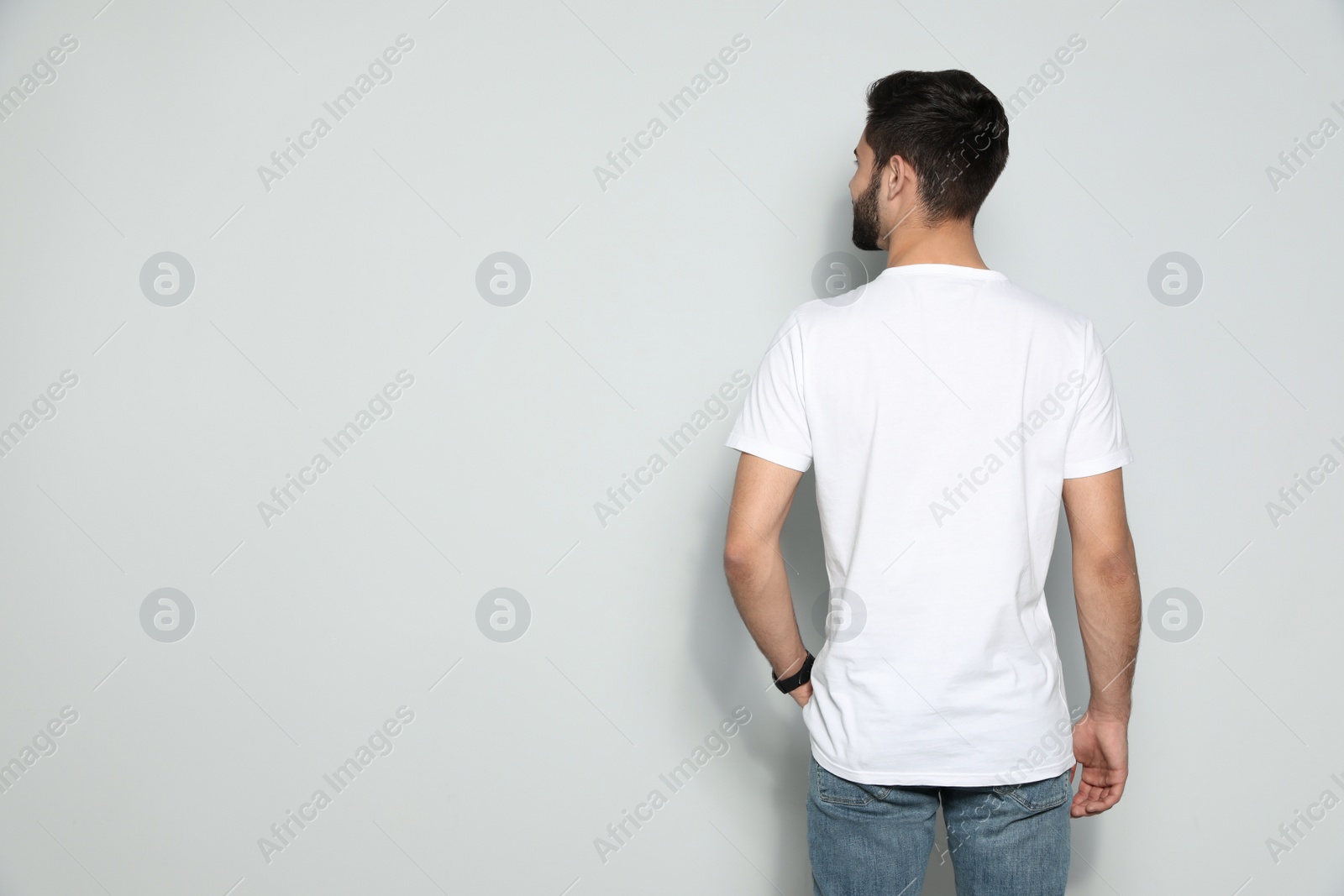 Photo of Young man in t-shirt on light background. Mock up for design