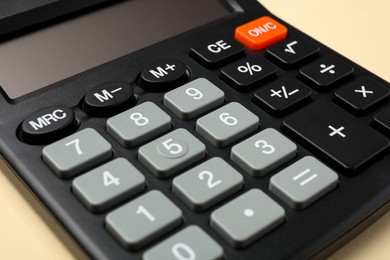 Photo of Calculator on beige background, closeup. Office equipment