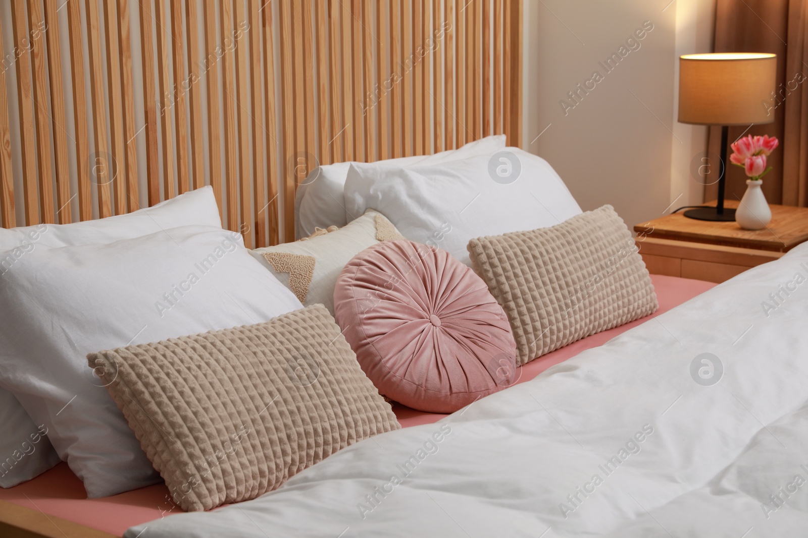 Photo of Comfortable bed with cushions in bedroom. Interior design