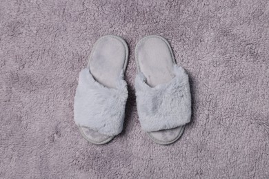 Photo of Soft slippers on grey fluffy carpet, top view