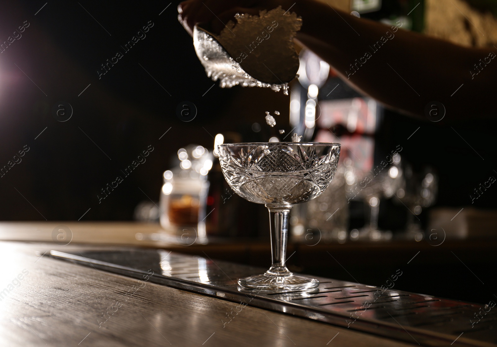 Photo of Bartender preparing fresh alcoholic cocktail at bar counter, closeup