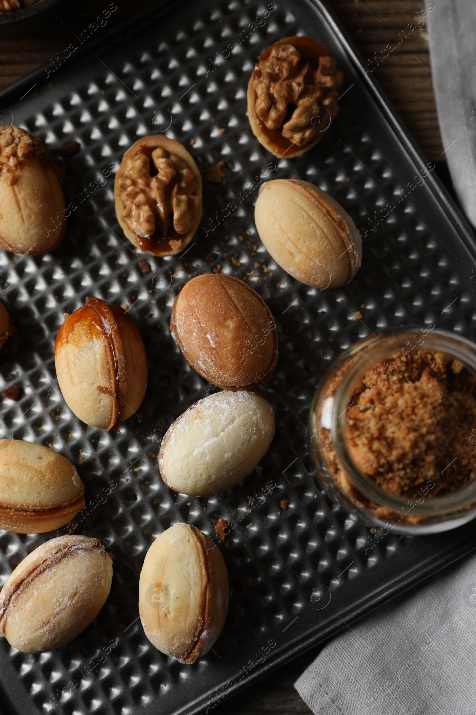 Photo of Freshly baked homemade walnut shaped cookies on wooden table, top view