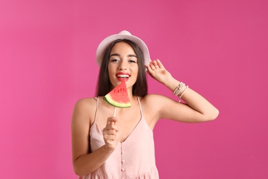 Beautiful young woman posing with watermelon on color background