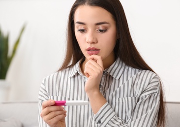 Photo of Young woman with pregnancy test at home. Gynecology and childbirth