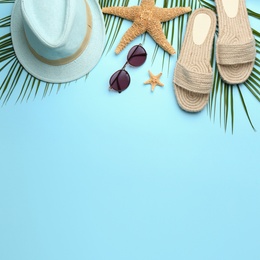 Photo of Beach accessories on light blue background, flat lay. Space for text