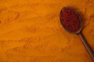 Photo of Spoon of dried flower stigmas on saffron powder, top view. Space for text