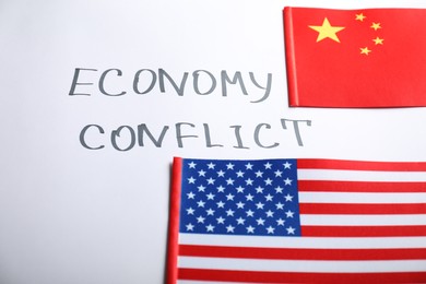 USA and China flags near words ECONOMY CONFLICT on white background