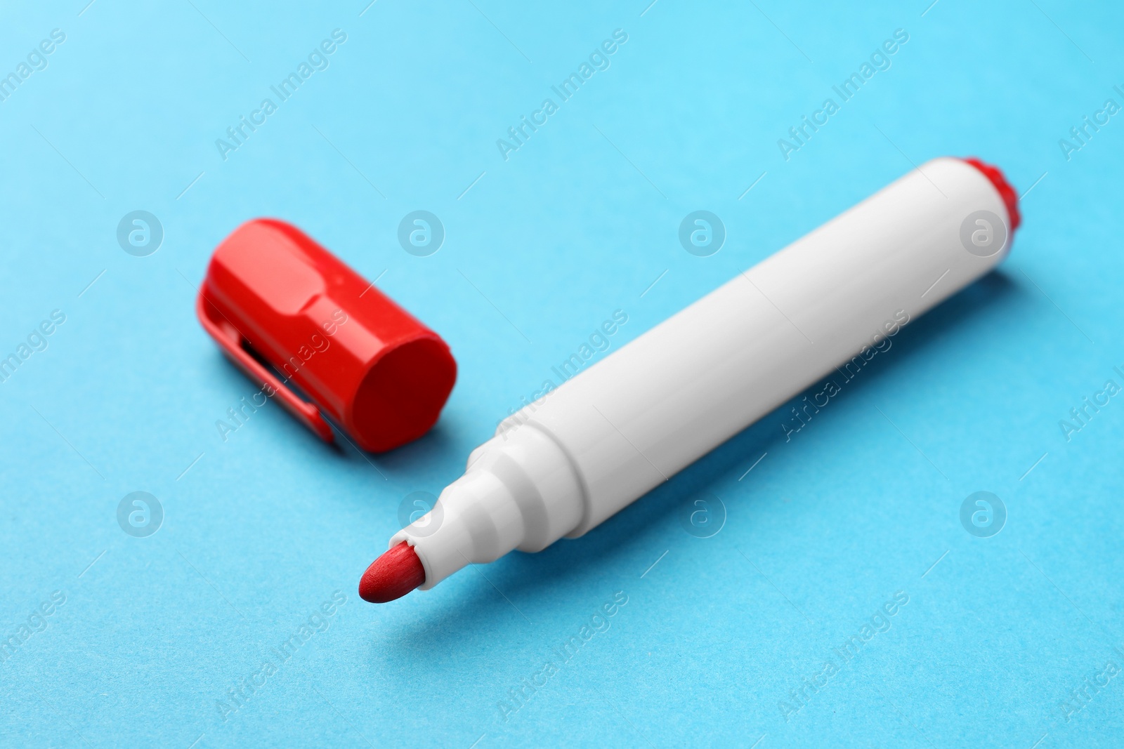 Photo of Bright red marker on light blue background