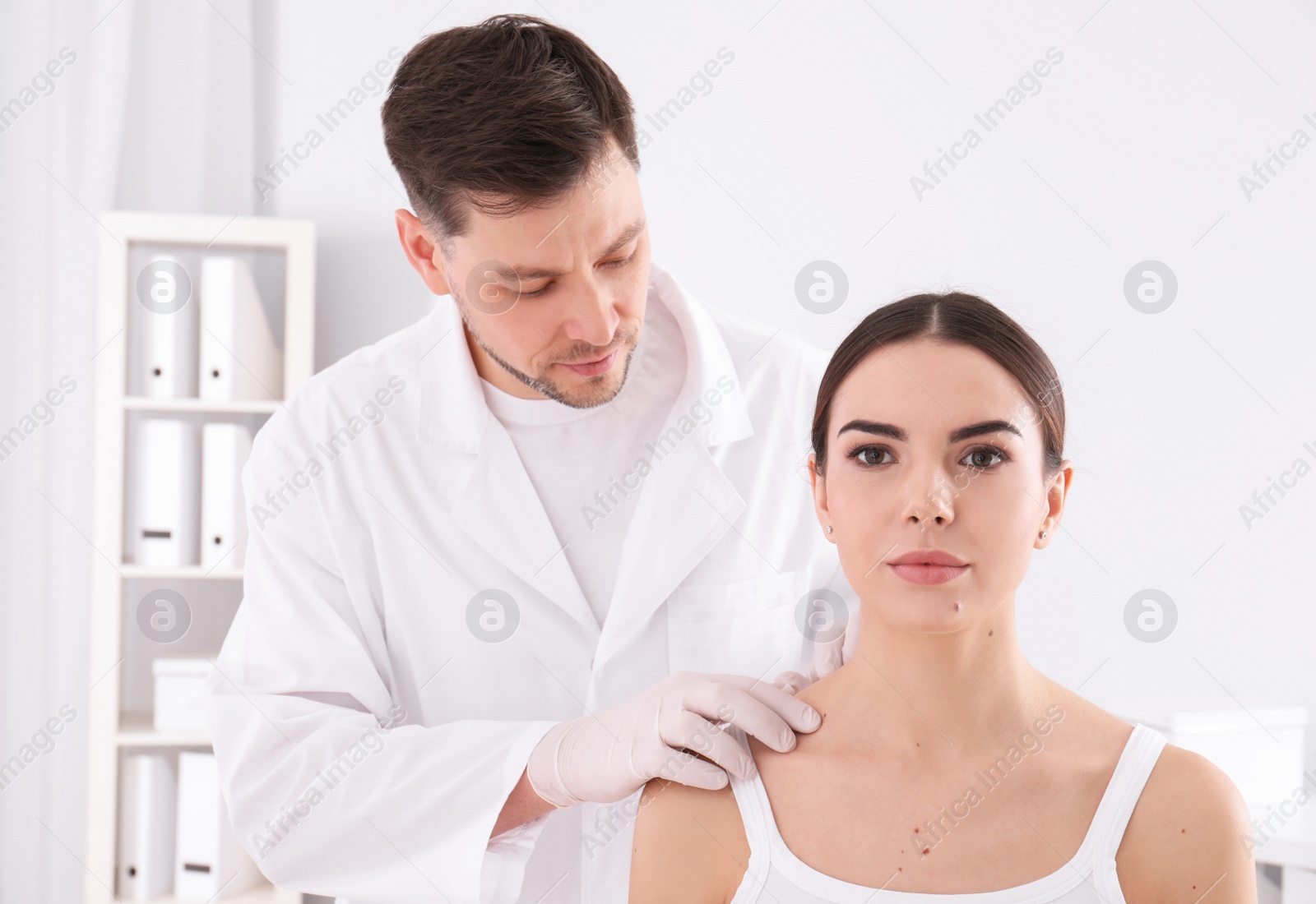 Photo of Doctor examining patient in clinic. Visiting dermatologist