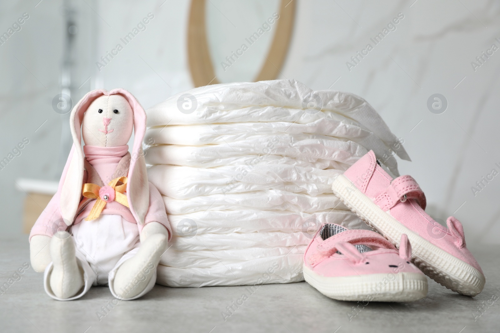 Photo of Stack of diapers and baby accessories on counter in bathroom, closeup