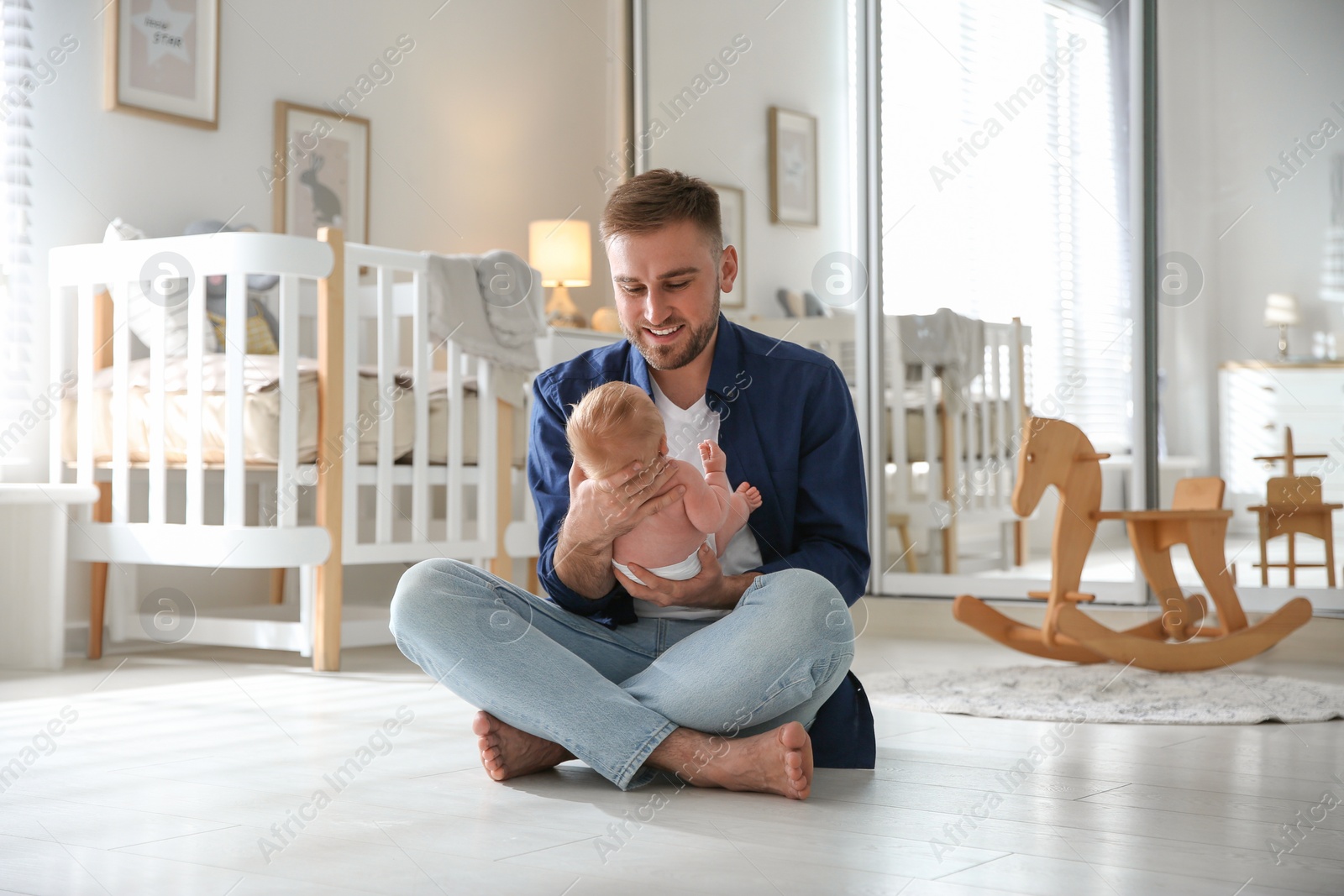 Photo of Father with his newborn son at home