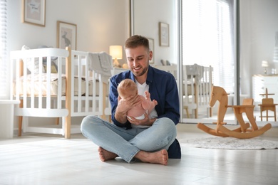 Photo of Father with his newborn son at home