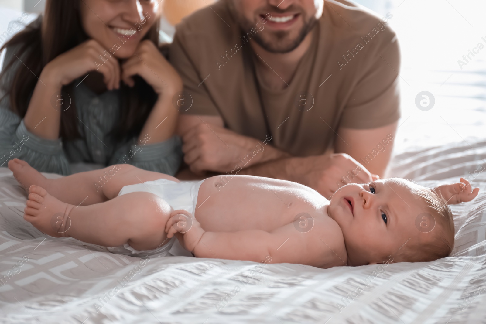 Photo of Happy couple with their newborn baby at home