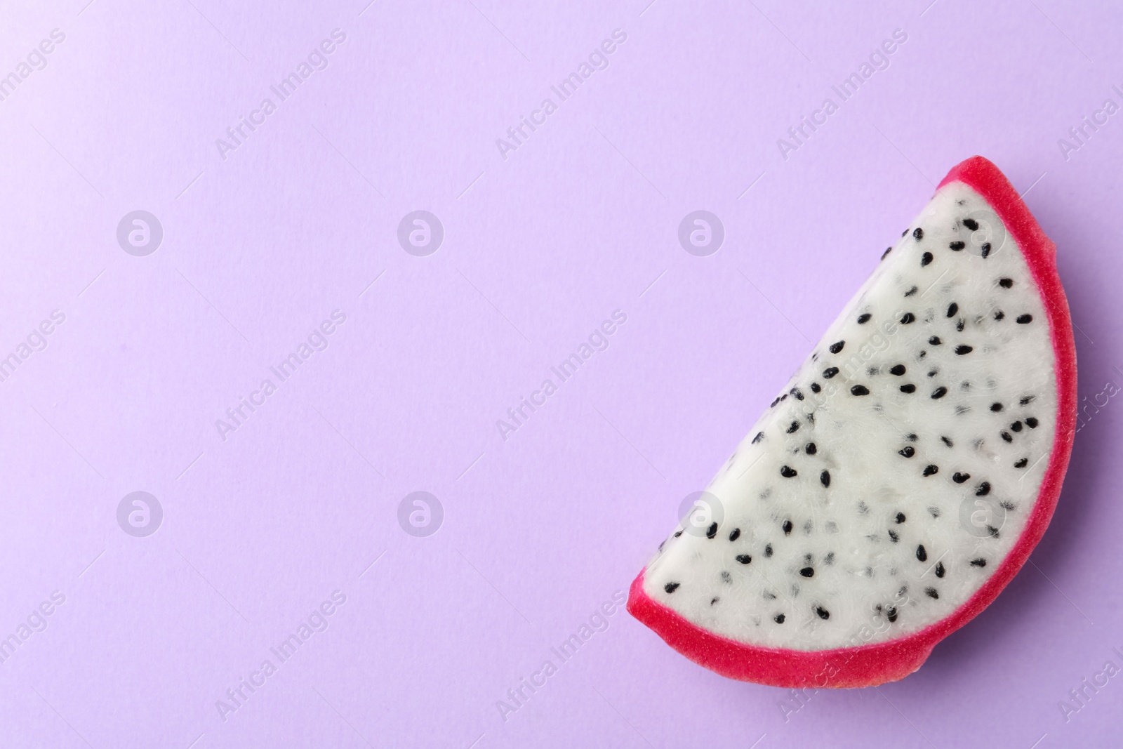 Photo of Slice of delicious dragon fruit (pitahaya) on violet background, top view. Space for text