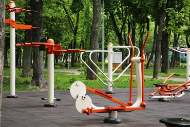 Photo of Empty outdoor gym with ovate stepper, rowing machine and push up bars