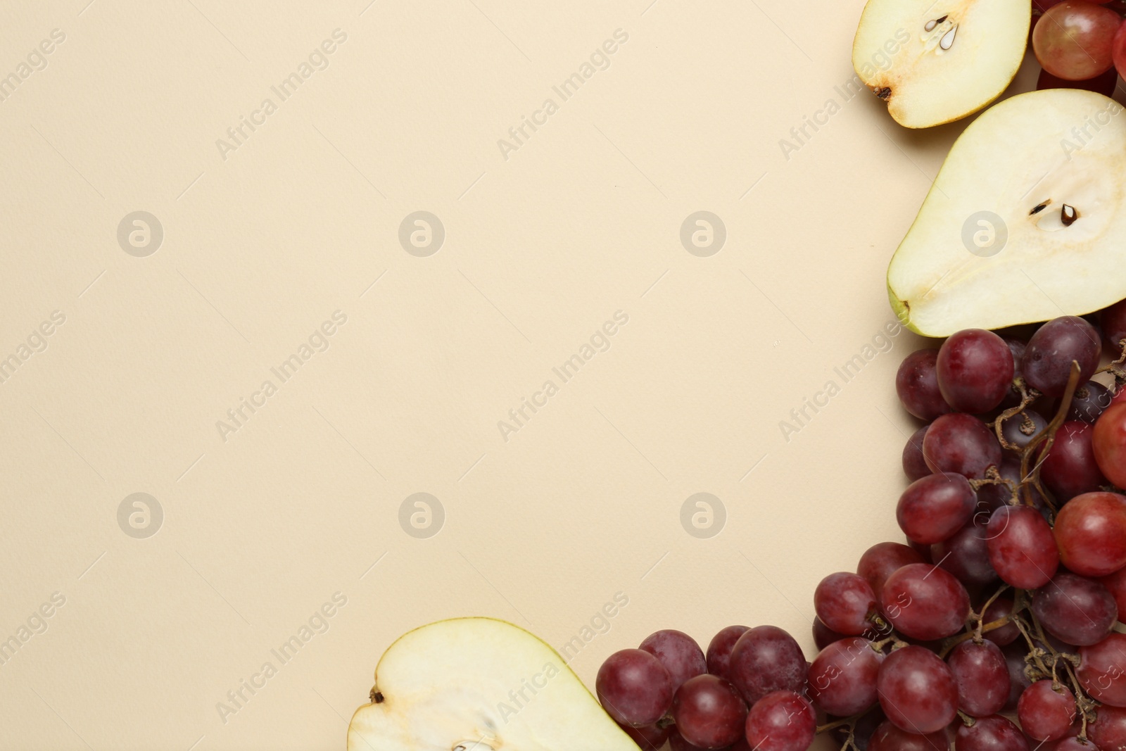 Photo of Fresh ripe pears and grapes on beige background, flat lay. Space for text