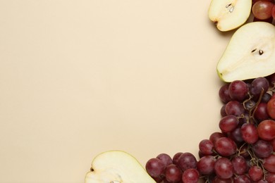 Fresh ripe pears and grapes on beige background, flat lay. Space for text