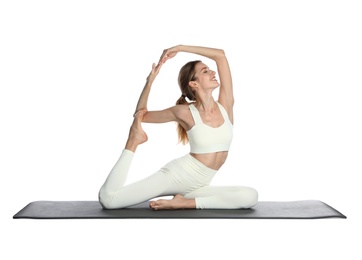 Photo of Young woman in sportswear practicing yoga on white background