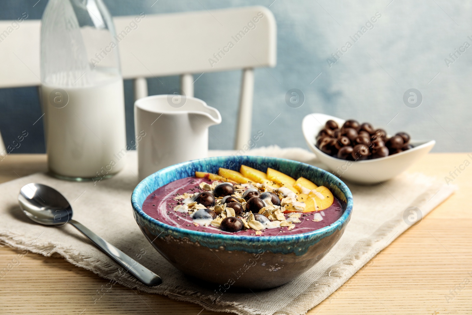 Photo of Bowl with tasty acai smoothie on wooden table