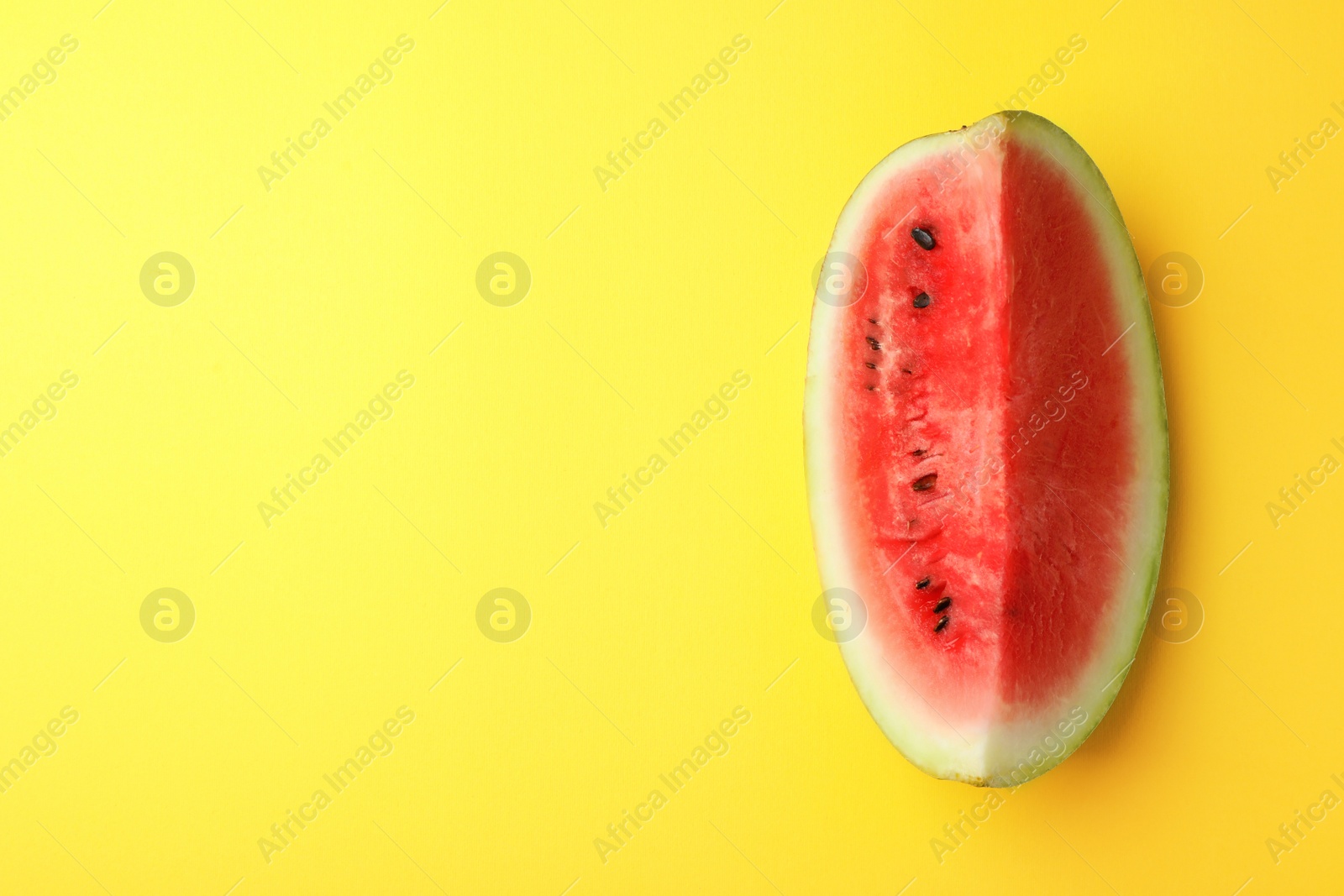 Photo of Slice of ripe watermelon on color background, top view with space for text