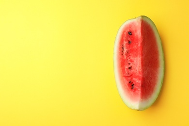 Photo of Slice of ripe watermelon on color background, top view with space for text