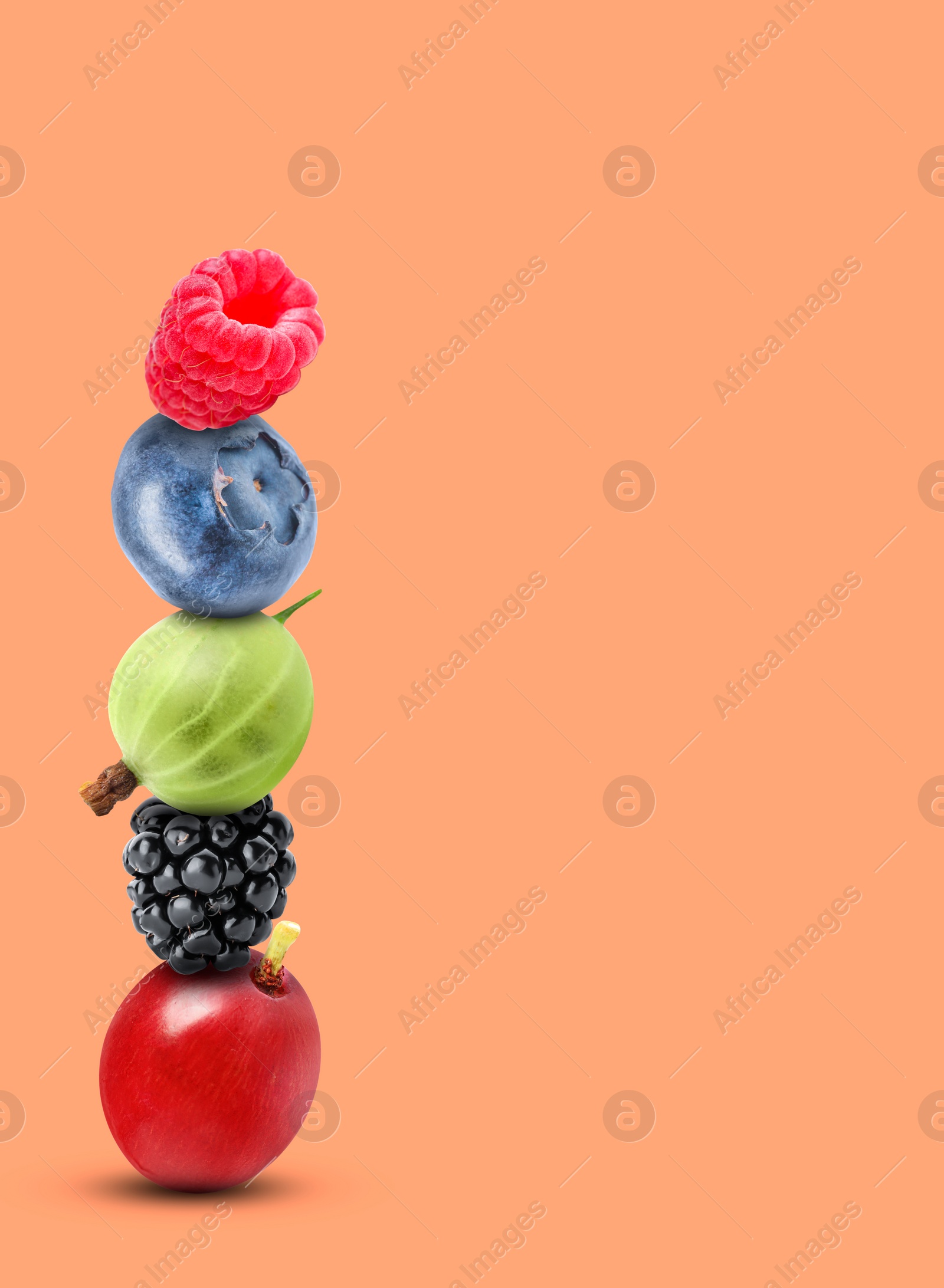 Image of Stack of different fresh tasty berries on light coral background, space for text
