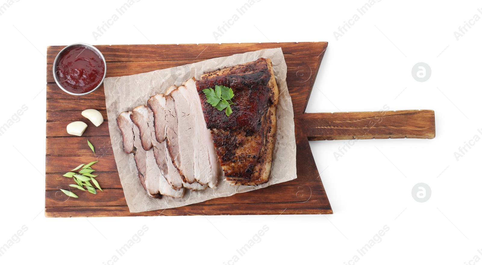 Photo of Pieces of tasty baked pork belly and sauce isolated on white, top view