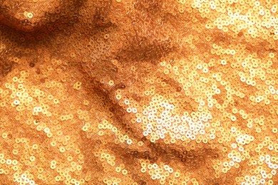 Photo of Beautiful golden shiny cloth with sequins as background, top view