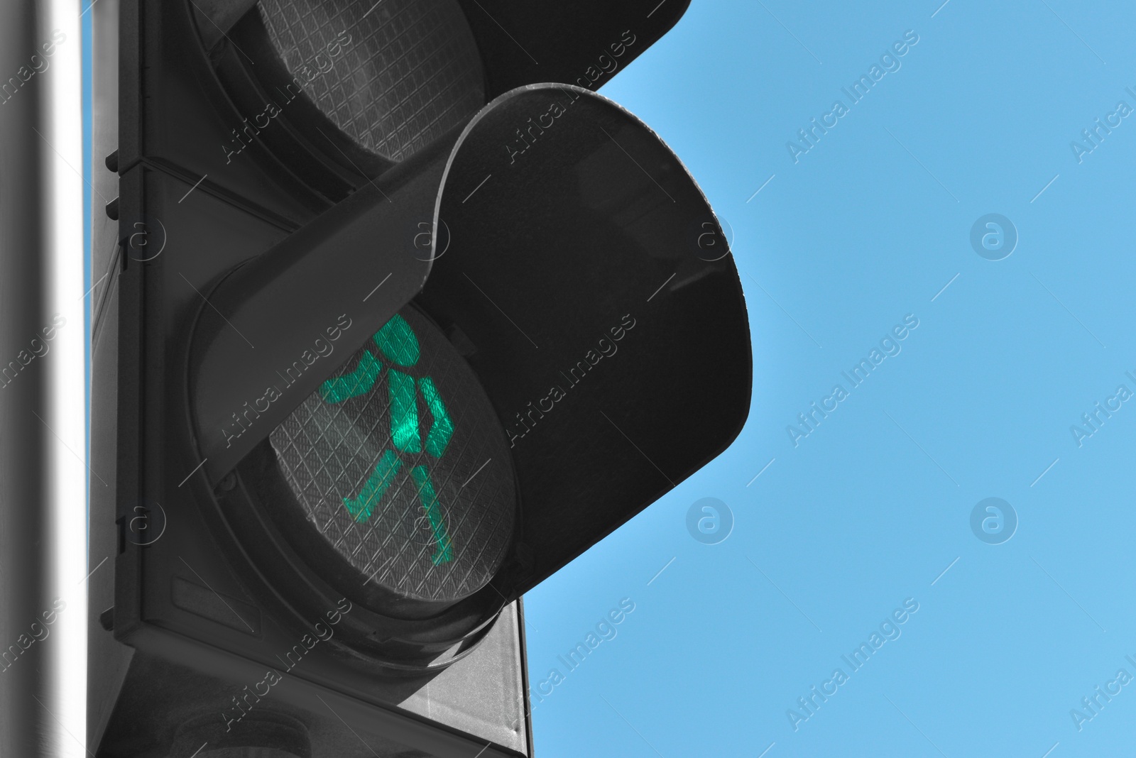 Photo of Traffic light with green signal against blue sky, closeup