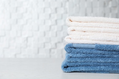 Stack of soft bath towels on table. Space for text