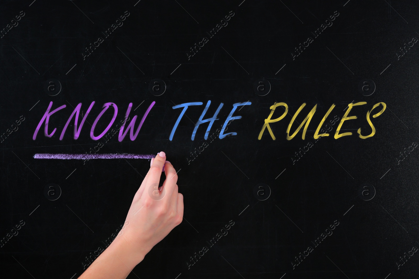 Image of Woman underlining phrase Know the rules on black chalkboard, closeup