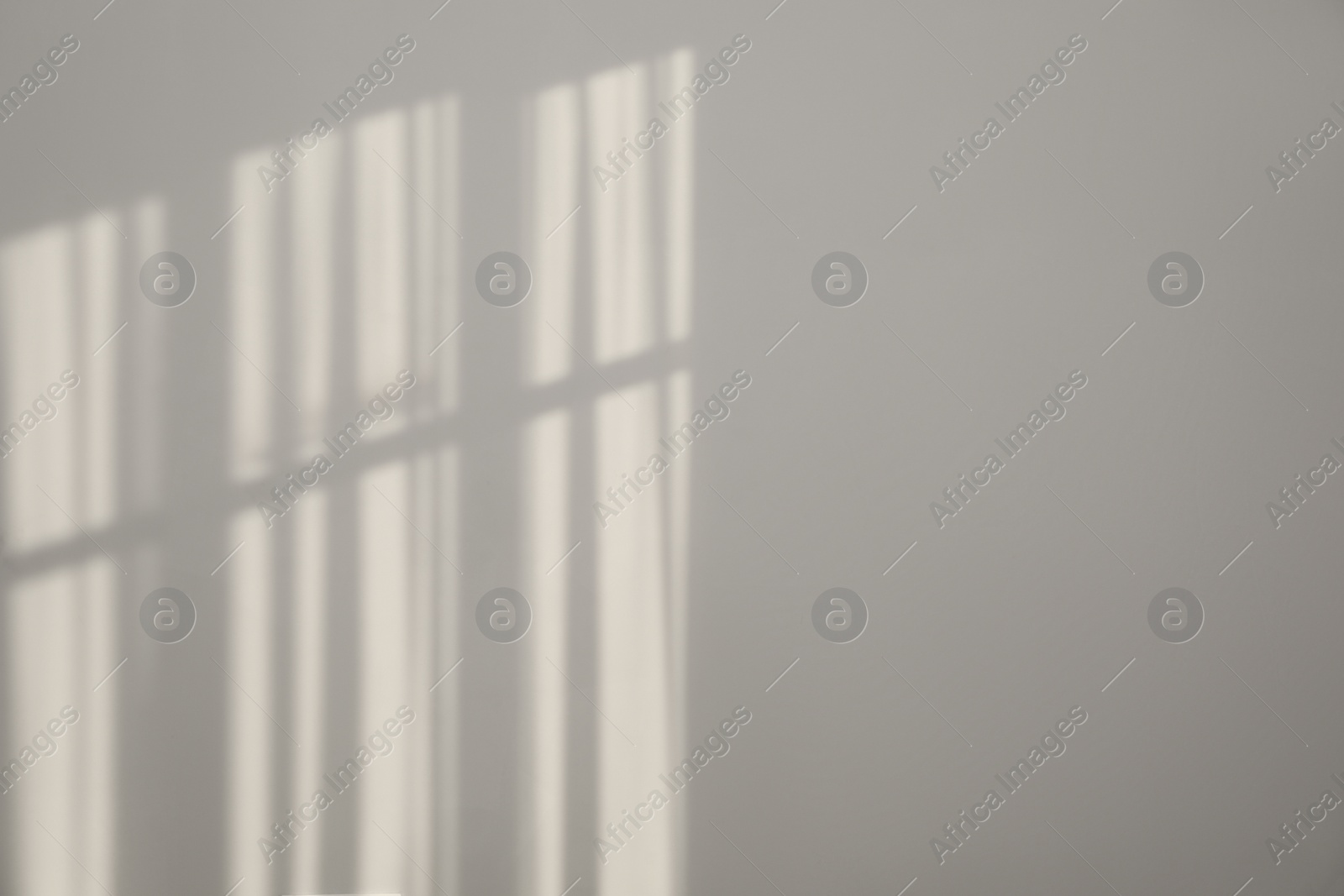 Photo of Light and shadows from window on wall indoors