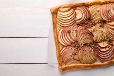 Freshly baked apple pie with nuts on white wooden table, top view. Space for text