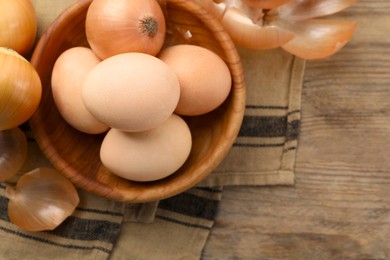 Easter eggs painted with natural dye and onions on table, flat lay