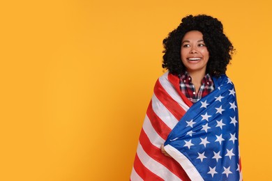Photo of 4th of July - Independence Day of USA. Happy woman with American flag on yellow background, space for text