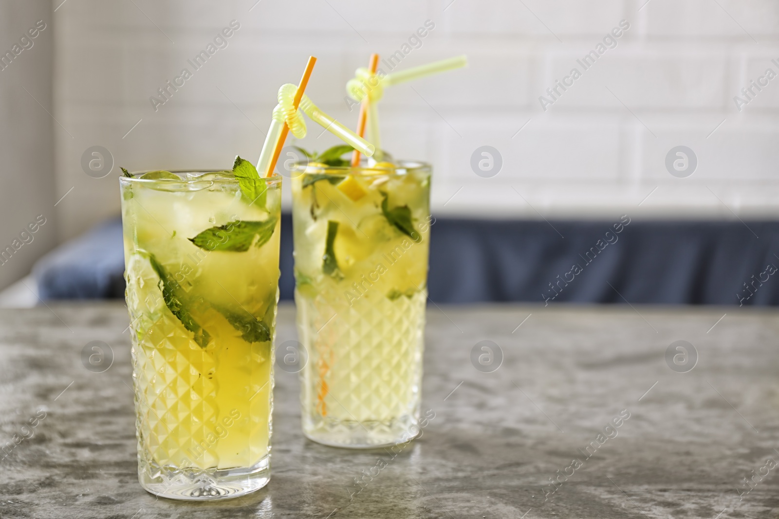 Photo of Glasses of iced lemonade on table indoors