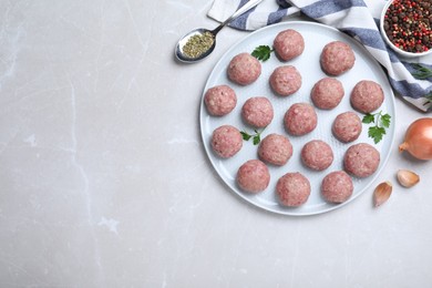 Many fresh raw meatballs on light table, flat lay. Space for text