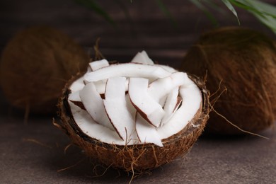 Coconut pieces in nut shell on brown table