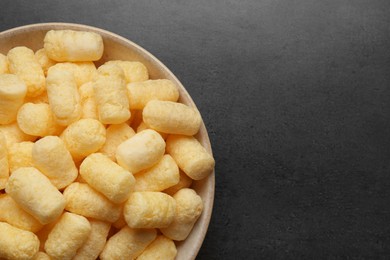 Photo of Plate of corn sticks on dark grey table, top view. Space for text