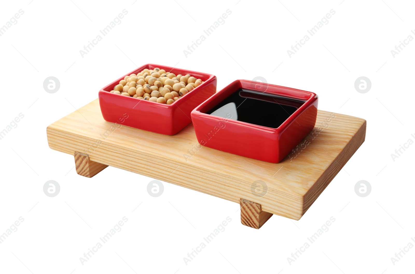 Photo of Wooden stand with dishes of soy sauce and beans on white background