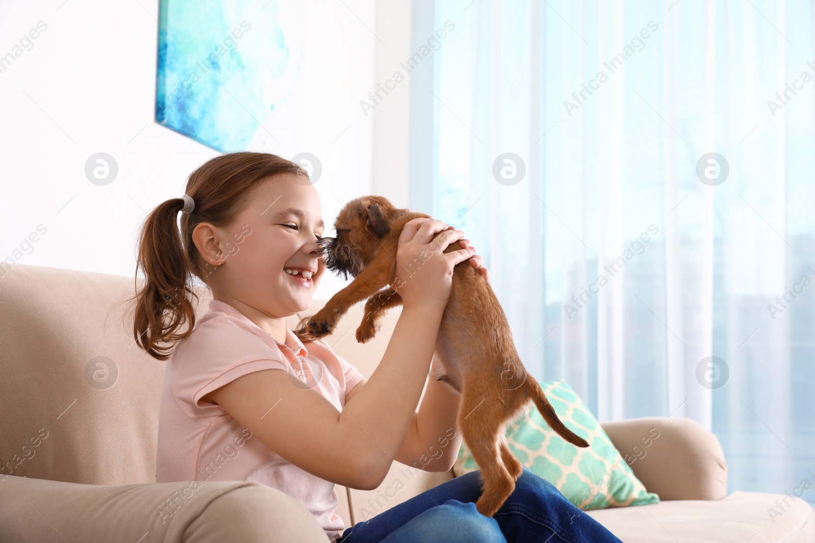 Photo of Portrait of cute girl with funny Brussels Griffon dog at home, space for text. Loyal friends